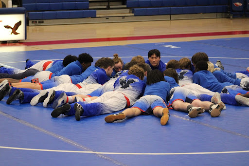 The wrestling team huddles before a dual meet against Howard on January 25.