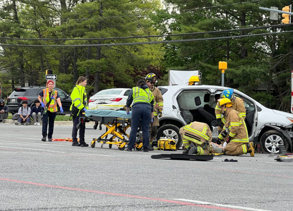 First responders acting in a simulated car crash in front of Centennial High School